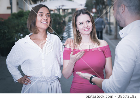 Young male is acquaintance with girls who are walking 39572182