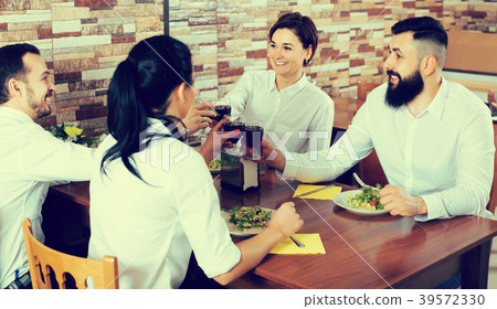 Cheerful group of friends at restaurant table Cheerful group of friends at restaurant table 39572330
