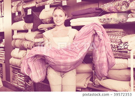 Youngwoman buying bed spread in textile store 39572353