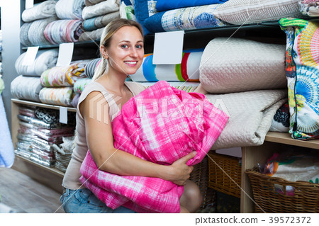 Young female customer choosing blanket 39572372