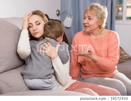 Two adult female are having disagreements with upbringing kid 39572450
