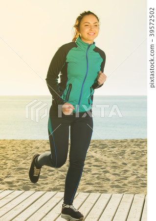 Charming woman running on beach Charming woman running on beach 39572502