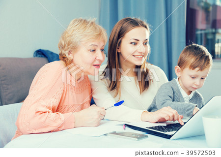Woman is talking her mother how to fill utility bills with laptop Woman is talking her mother how to fill utility bills with laptop 39572503