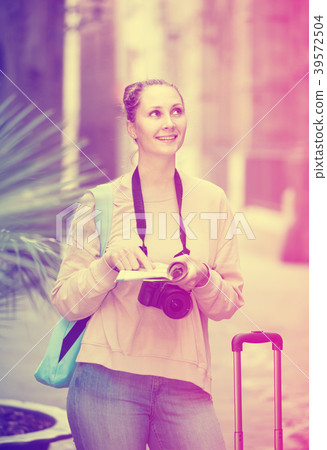 Girl having pamphlet and looking for her route in city Girl having pamphlet and looking for her route in city 39572504