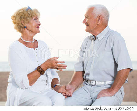 pensioners woman and man sitting and talking pensioners woman and man sitting and talking 39572544