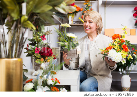 Woman selecting flowers in store Woman selecting flowers in store 39572699