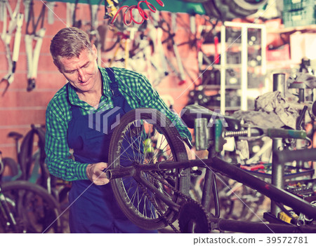 seller in uniform repairing bicycle seller in uniform repairing bicycle 39572781