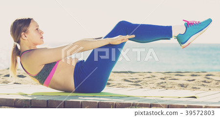 Smiling adult female is practicing set of stretching exercises Smiling adult female is practicing set of stretching exercises 39572803