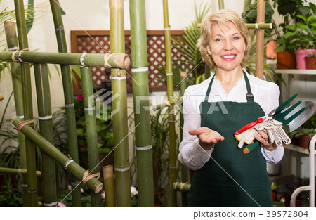 Florist in apron holding tools 39572804