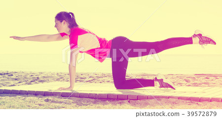 Girl practicing yoga poses on beach 39572879