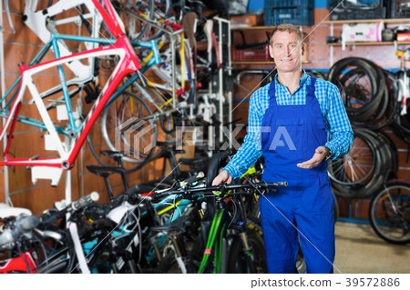 Positive man seller in uniform working with bicycle Positive man seller in uniform working with bicycle 39572886