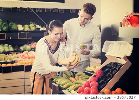Couple choosing fruits in shop Couple choosing fruits in shop 39573027