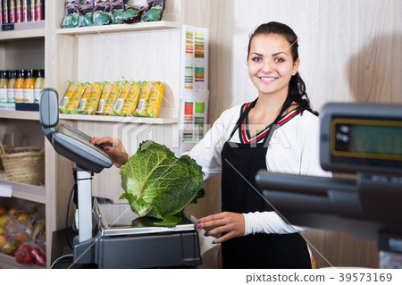 Smiling woman seller weighing cabbage Smiling woman seller weighing cabbage 39573169