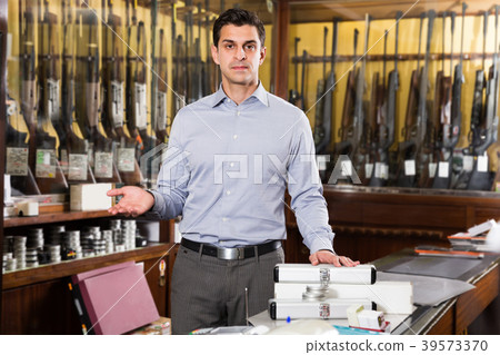 Male seller offering necessary hunting equipments 39573370