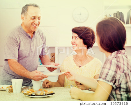 senior man serving family lunch at home . 39573516