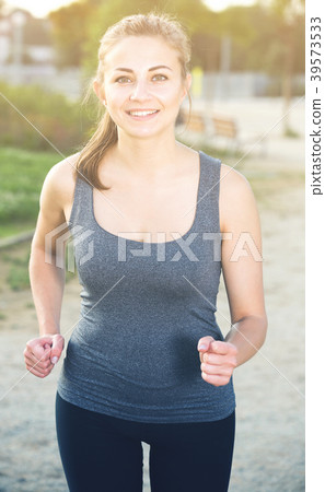positive female in sportwear running in the sunny park positive female in sportwear running in the sunny park 39573533