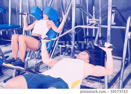 Man making bench press exercise using gym machinery Man making bench press exercise using gym machinery 39573552