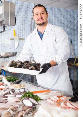 Man holds in hand container with big mussels 39573822