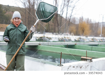 Portrait of female with landing net on fish farm Portrait of female with landing net on fish farm 39574043