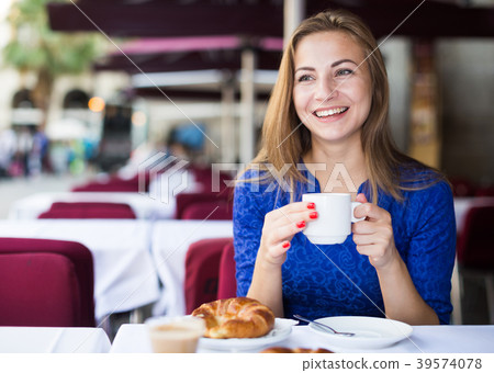 Girl is drinking coffee with croissant in time breakfast 39574078