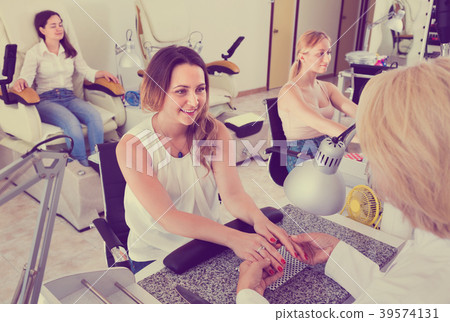 Two women clients having manicure done in nail salon 39574131