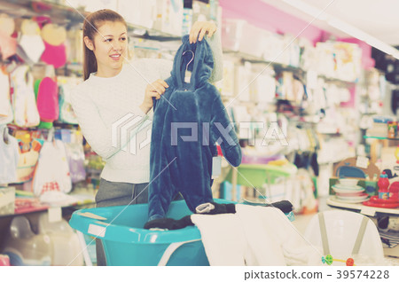 smiling pregnant female is buying clothes for baby in thestore 39574228