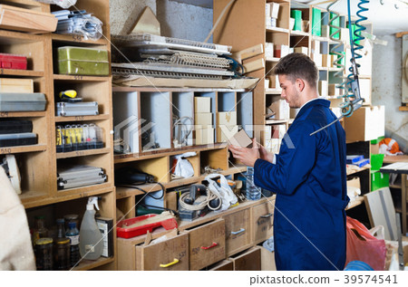Man looking through stored items at workshop 39574541