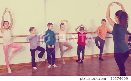 industrious boys and girls rehearsing ballet dance in studio 39574609