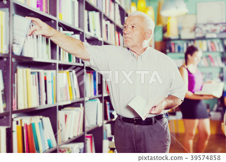 Mature person is choosing book Mature person is choosing book 39574858