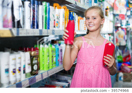 Smiling girl holding shampoo and conditioner in the hand 39574966