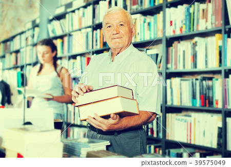 Mature male is showing book that he bought 39575049