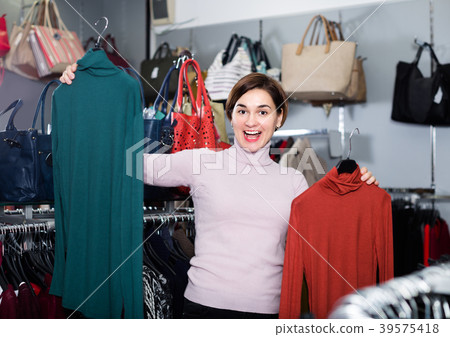 Adult girl is deciding on turtleneck sweater 39575418