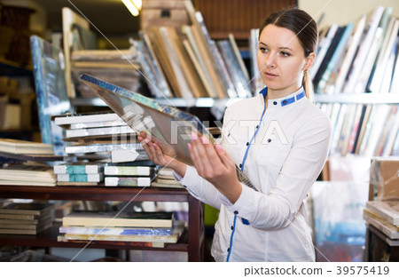 Nice woman is standing with modern pictures 39575419