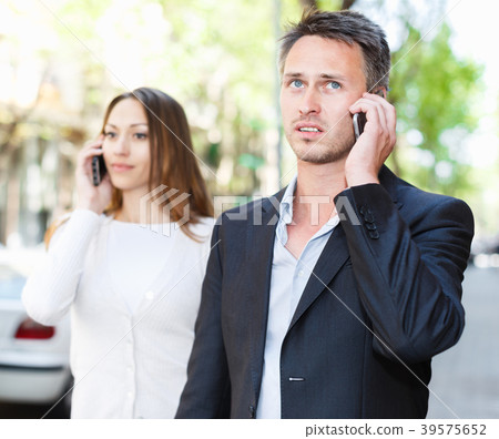 Girl and guy speaking on phones 39575652
