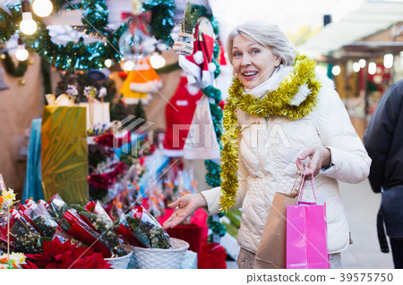 Female buying decoration and brush of tree at Christmas Fair 39575750
