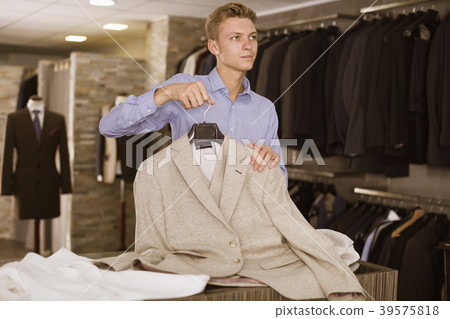 Adult male selling jacket in the store 39575818