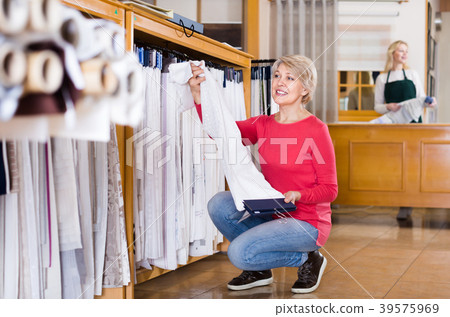 Adult woman choosing interesting fabric Adult woman choosing interesting fabric 39575969