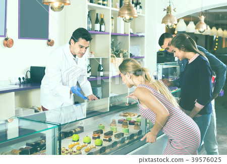 Friends are choosing cakes from showcase Friends are choosing cakes from showcase 39576025