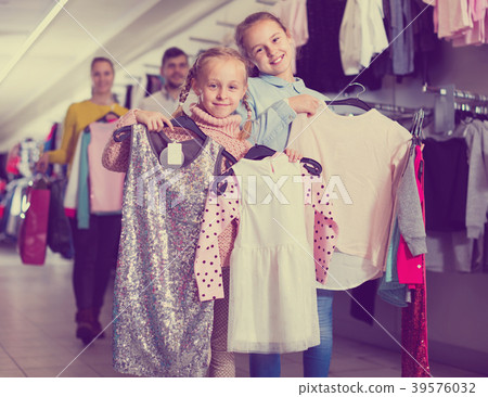 Portrait of two happy little girls and theirs parents with new clothes in shopping mall Portrait of two happy little girls and theirs parents with new clothes in shopping mall 39576032