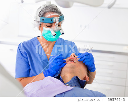 adult dentist checking teeth of patient male sitting in medical center 39576243