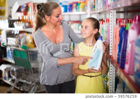 Woman with girl are choosing goods in chemistry rows 39576259