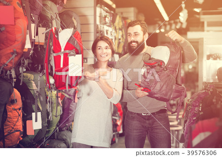 Guy and a girl choose a big backpack Guy and a girl choose a big backpack 39576306