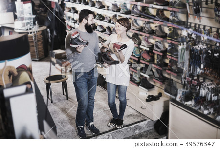 Couple choosing sneakers in store Couple choosing sneakers in store 39576347