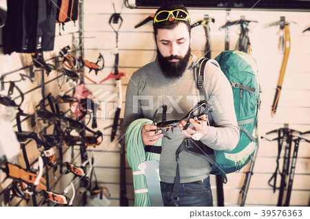 Man choosing climbing equipment Man choosing climbing equipment 39576363
