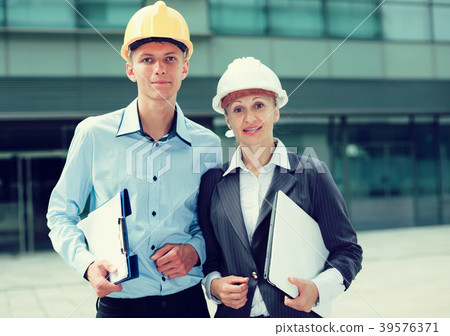 Female designer and her partner are standing with laptop and folder 39576371