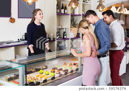 Glad female helping customers to choose sweets Glad female helping customers to choose sweets 39576374