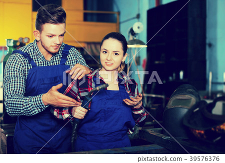 Master is helping woman to working with burning Master is helping woman to working with burning 39576376