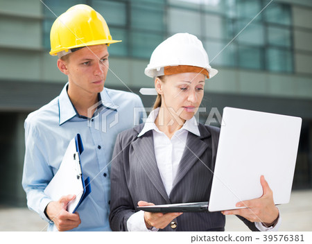 Smiling architectors are exploring project in laptop Smiling architectors are exploring project in laptop 39576381