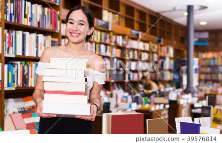 woman with stack of books in bookstore woman with stack of books in bookstore 39576814