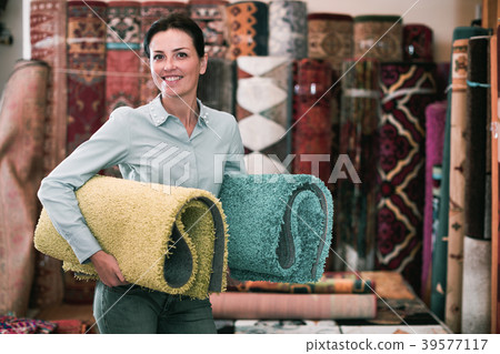 Cheerful woman customer shopping carpet in store Cheerful woman customer shopping carpet in store 39577117